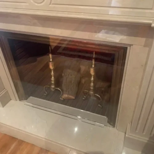Chimenea con cubierta protectora de metacrilato en salón moderno